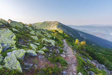 Fototapeta na wymiar Journey through the mountain ranges and tops of the Ukrainian Carpathians, a tourist with a tent in a beautiful summer weather with fantastic sunrises and sunsets.