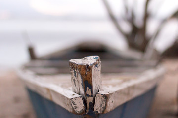 Detail of a wood fisherman's boat prow painted in blue and white, Paqueta, Rio de Janeiro, Brazil. Blurred background with cloud sky. 2017