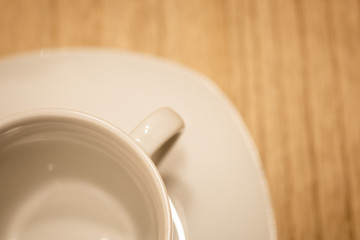 Eine leere Tasse mit Untersetzer auf einem Holztisch