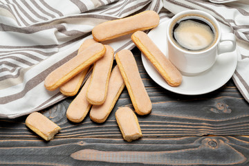 Italian Savoiardi ladyfingers Biscuits and cup of coffee on wooden backgound