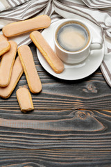 Italian Savoiardi ladyfingers Biscuits and cup of coffee on wooden backgound