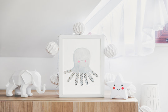 Stylish and cute nursery interior with mock up photo frame , star , elephant figure and cotton lapms on the wooden shelf. Bright and sunny room with white background wall. 