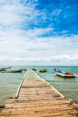 Fototapeta na wymiar Wooden landing stage with anchored boats, Los Roques National Park