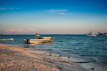 Fototapeta premium Boats anchored during a dramatic and beautiful sunset. Los Roques National Park 