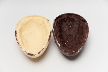 Delicious homemade Easter egg, 2 flavors: coconut and truffle. Isolated on white background. Horizontal image. Split in half.