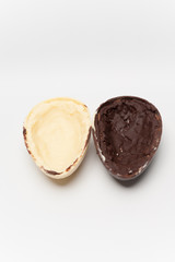 Delicious homemade Easter egg, 2 flavors: coconut and truffle. Isolated on white background. Vertical image. Split in half.