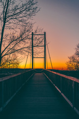Obraz premium Low angle view of a silhouetted bridge at sunset