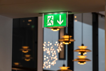 green exit sign with lamps at background