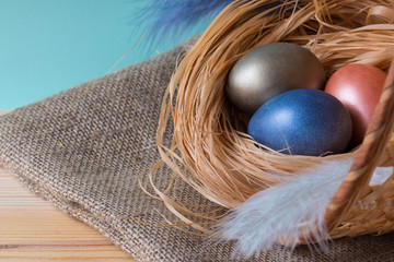 The easter background with Easter eggs in a basket on a wooden background