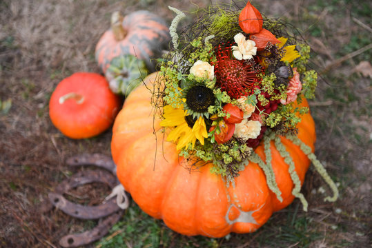 Autumn floral bouquet in a pumpkin vase for Halloween. Table setting and  floral decor for a rustic wedding Stock Photo | Adobe Stock