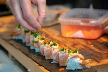 serving sushi pieces with fresh greens