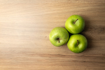 Three apples on a wooden table