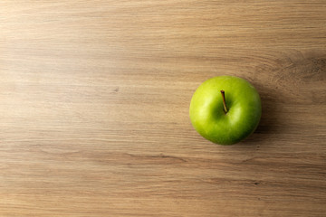 Green apple on wooden table