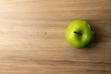 Green apple with one bite missing