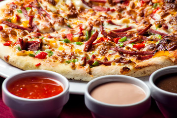 Delicious pizza with with sauces on the table. Food concept