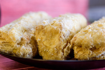 Napoleon cakes on a red wooden background.
