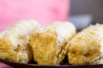 Napoleon cakes on a red wooden background.