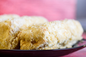 Napoleon cakes on a red wooden background.