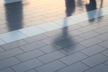 Diffuse reflections of pedestrians walking a marble sidewalk in dubai