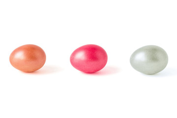 The eggs of three colors isolated on a white background. Pink, orange, silver