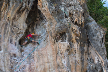 Men wearing red shirts are climbing high rocks,Extreme sports activities for the strength of the test,Concept: expedition aim for success and freedom lifestyle