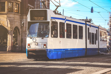 Fototapeta na wymiar Blue city tram on street in Amsterdam, Netherland