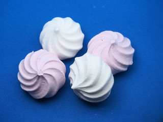 Meringue cookies pink and white on a blue background.