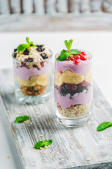 granola in a glass with yogurt and berries on a white background