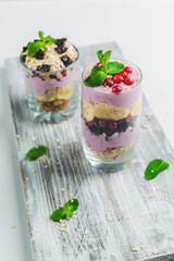 granola in a glass with yogurt and berries on a white background