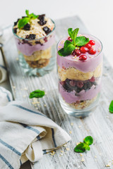 granola in a glass with yogurt and berries on a white background