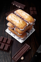 tower of homemade sponge biscuits and pieces of chocolate on dark classic wood