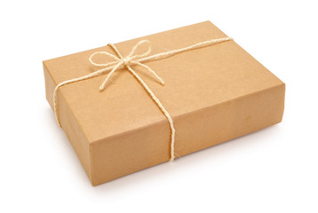 Parcel wrapped in brown paper, tied with rope and knot. Isolated on white background. Contains clipping path.