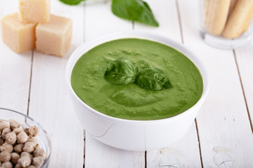 Green cream soup of spinach and chickpeas on concrete wood background