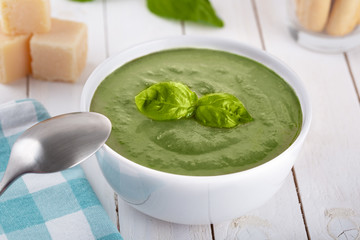 Green cream soup of spinach and chickpeas on concrete wood background