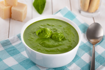 Green cream soup of spinach and chickpeas on concrete wood background