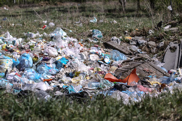 Environmental pollution. Rubbish in the green grass on nature. Ruined landscape. Stock background, photo