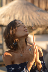 beautiful woman with brunette hair in dark swimwear and mirror glasses posing in blue pool in Bali
