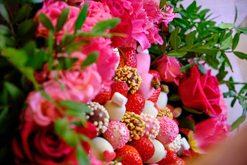 A delicious bouquet of strawberries and roses. close-up on the table