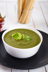 Green cream soup of spinach and chickpeas on concrete wood background