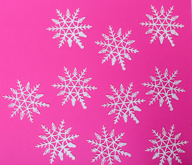 Naklejka na ściany i meble Pink background with white snowflakes