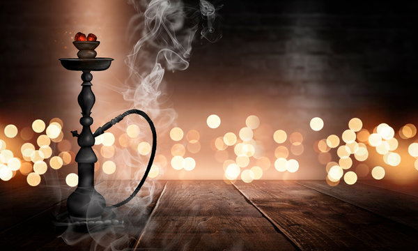 Hookah in a dark room with smoke, abstract bokeh light, wooden table, wet asphalt, reflection.