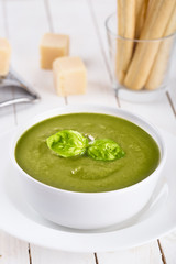 Green cream soup of spinach and chickpeas on concrete wood background