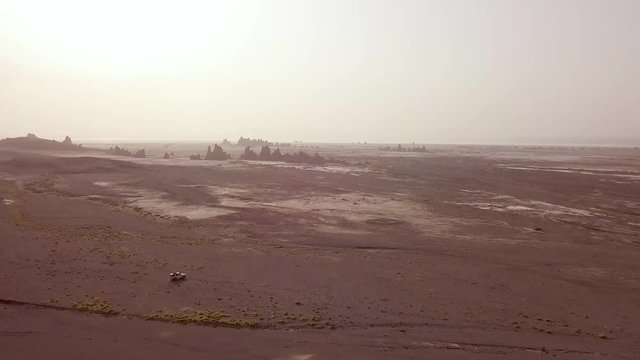Good aerial over a 4 WD jeep driving across a wild and rugged landscape in Djibouti or Somalia.