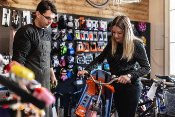 Fototapeta na wymiar Young woman in bicycle shop.