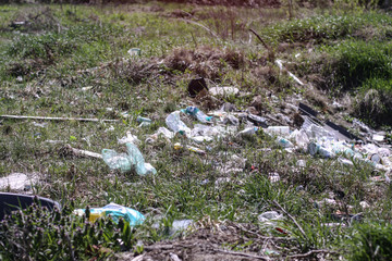 Environmental pollution. Rubbish in the green grass on nature. Ruined landscape. Stock background, photo