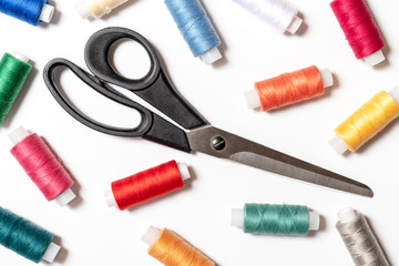 Colored thread coils and scissors on white background, sewing, handmade and DIY concept - design for seamstress and tailor articles and blog illustration