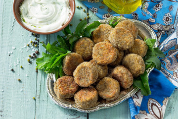 Middle eastern or arabic dishes. Fresh vegetarian falafel. Mung falafel with garlic yogurt sauce on wooden table. Copy space.