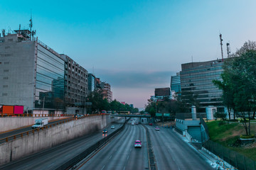 Fullshot of mexico city in the morning, a road with cars surrounded by buildings on blue sky in the center of Mexico city