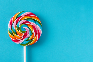 Colorful lollipop on blue background. Top view. Copyspace