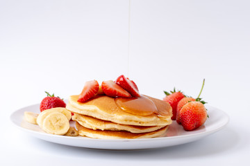 Homemade Pancakes with fresh strawberries and slice banana and honey on white plate,Healthy breakfast.